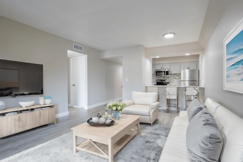 A modern living room with a white sofa and a wooden coffee table.